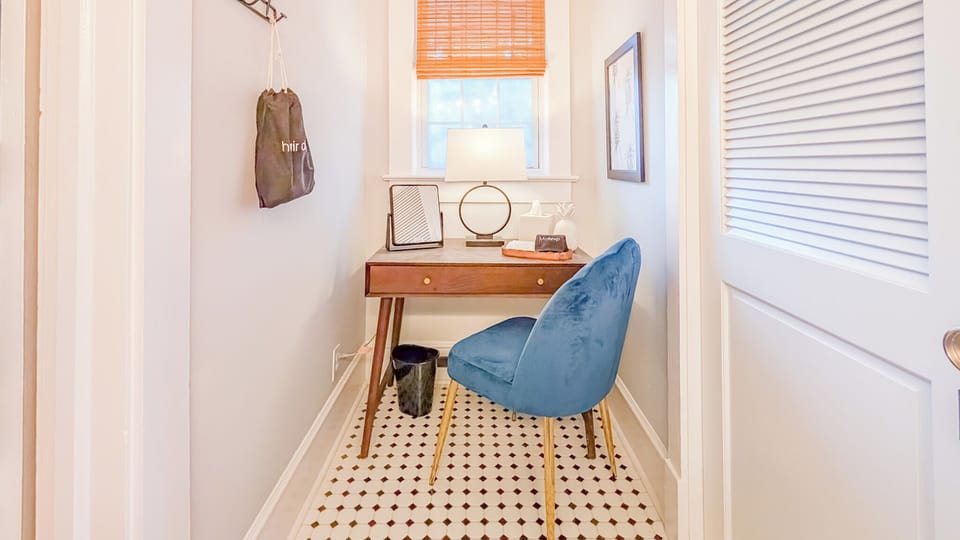 Dedicated sit down vanity space with mirror and lighting.