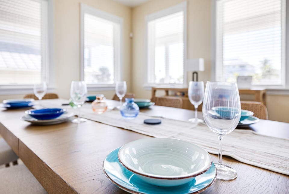Dining table styled with place settings, wine glasses, and a centerpiece, ready for entertaining