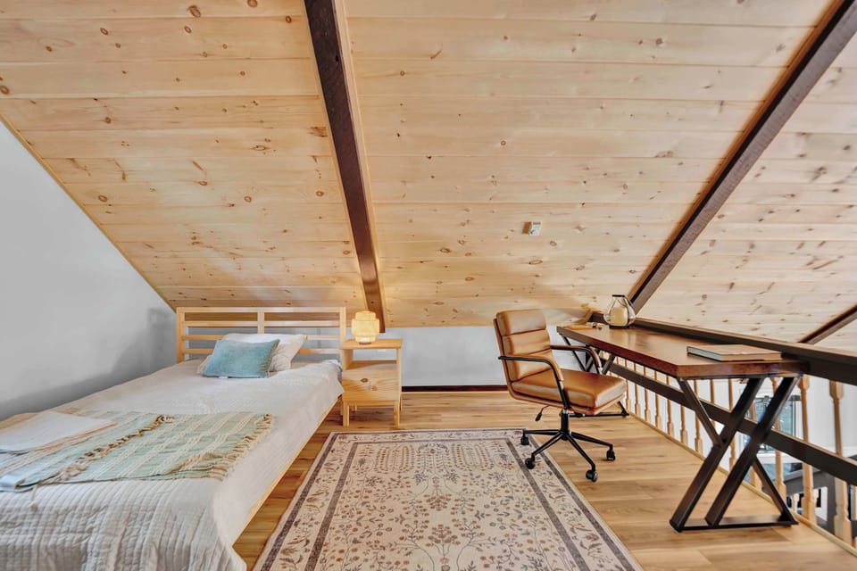 Bright Loft Sleeping Area with Skylight and Wood Beams