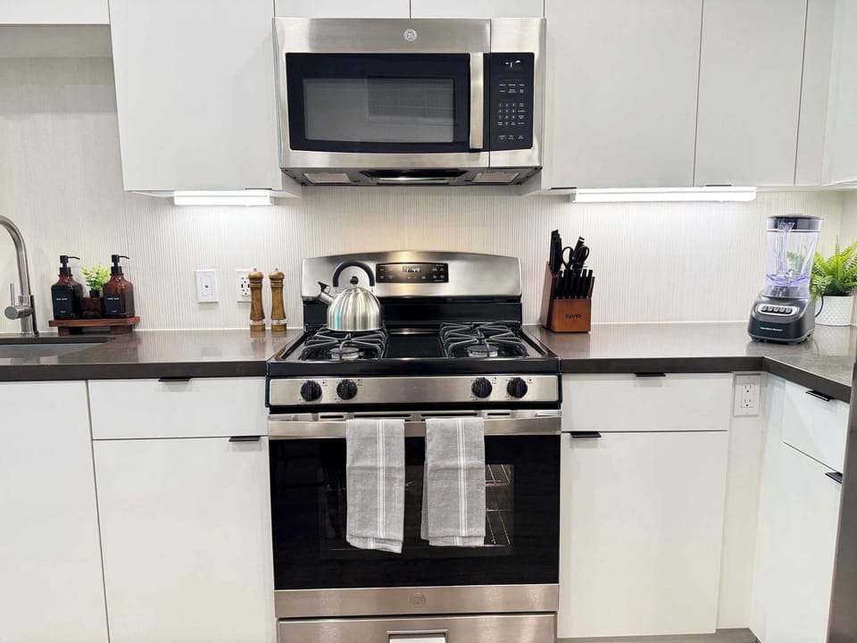 Experience extended comfort with a fully equipped kitchen featuring a coffee machine, stovetop, and microwave—everything you need for a seamless long-term stay.