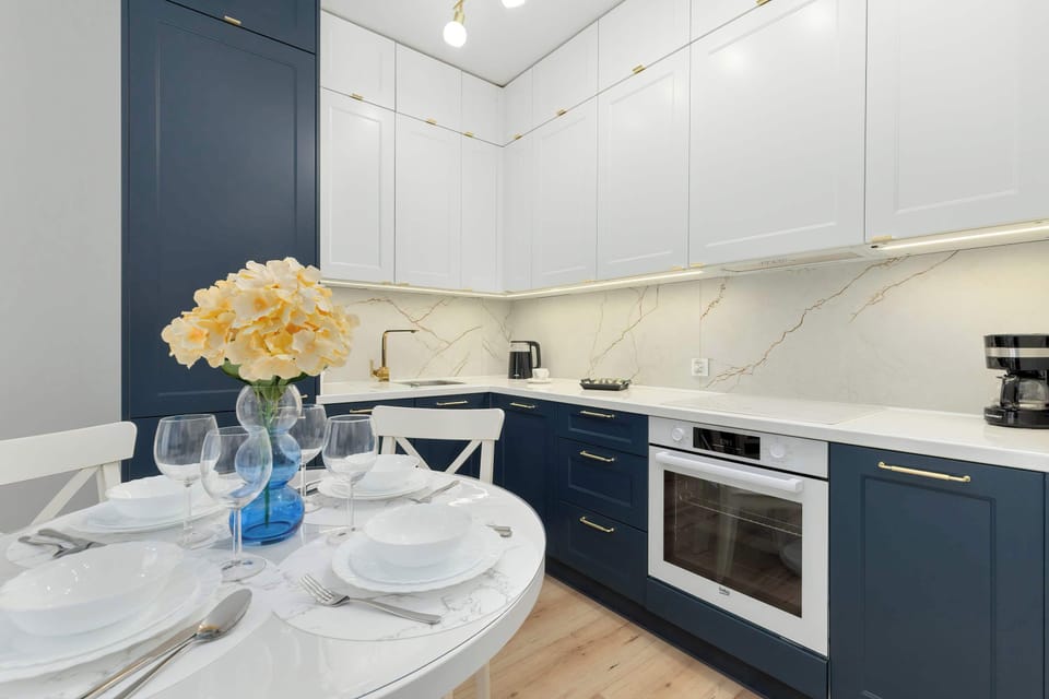 Stylish kitchen with deep blue cabinetry, white quartz countertops, and integrated modern appliances.