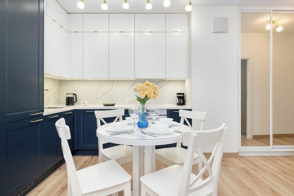 Bright dining area with a chic white table set and direct connection to the modern kitchen.