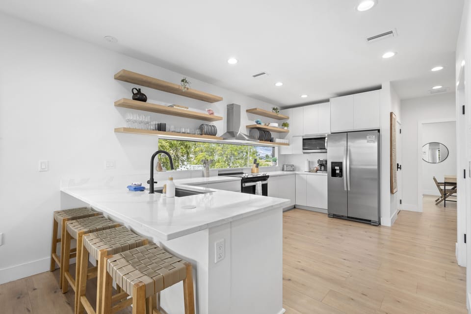 Sleek, modern, open-concept kitchen with spacious countertops, stainless steel appliances, and a bright, airy layout perfect for cooking and entertaining.