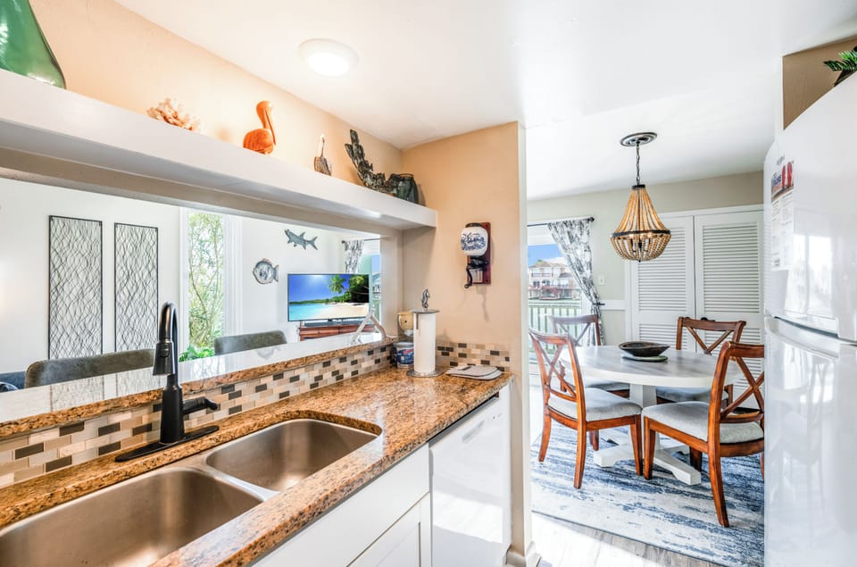 Your bright kitchen flows into the dining area, featuring granite counters and tropical touches for memorable meals.