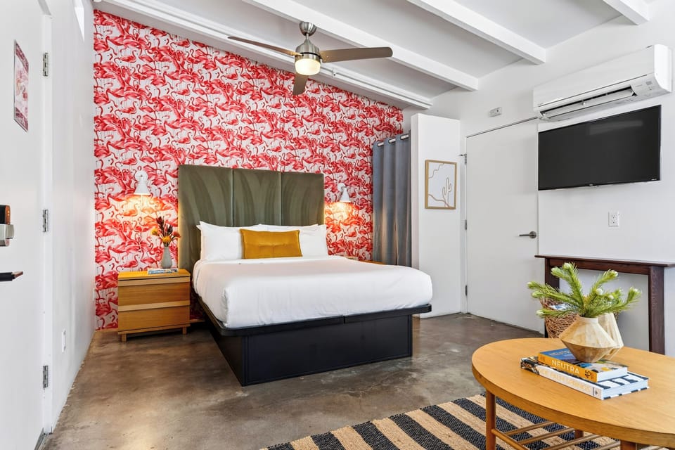 The Queen Studio features a plush queen bed, TV, ceiling fan, and vibrant Palm Springs style.
