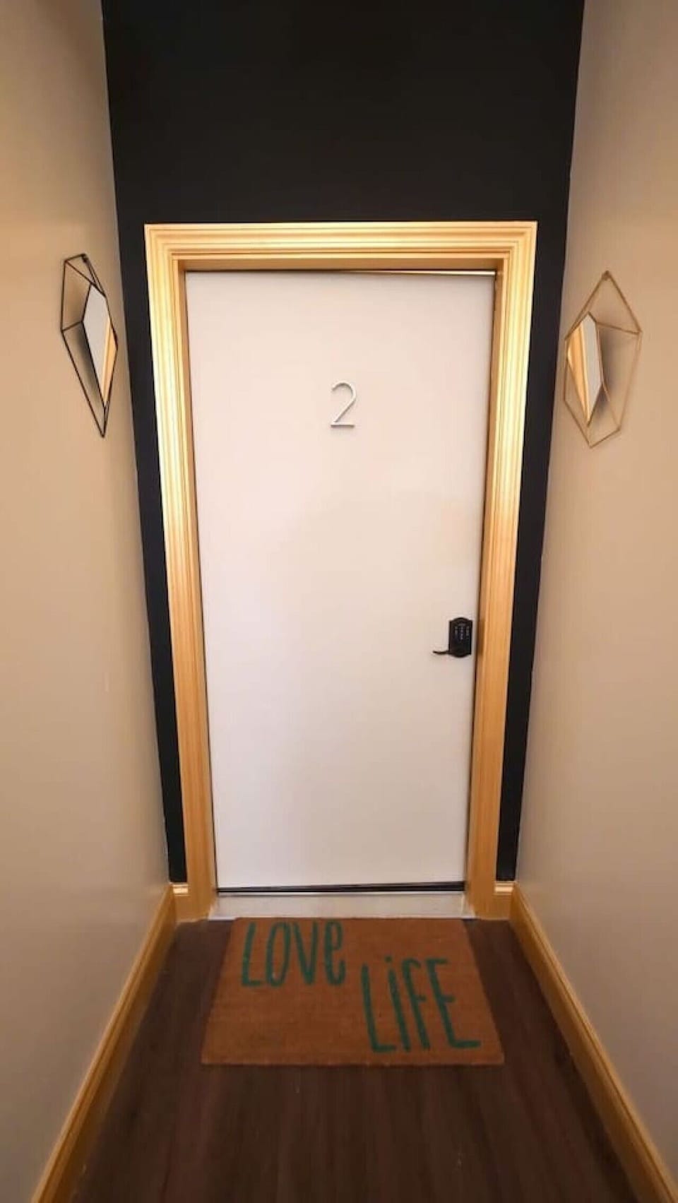 Tall gold-trimmed door leading into the unit, adding a touch of charm.