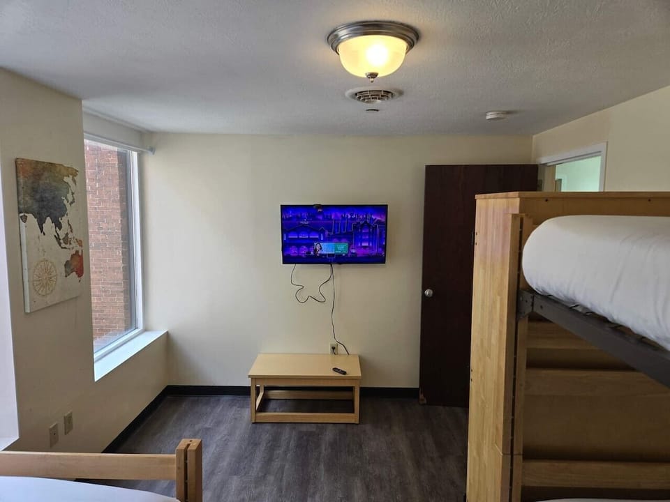 Comfortable shared bedroom featuring bunk beds, a smart TV, and a spacious layout perfect for groups or longer stays.