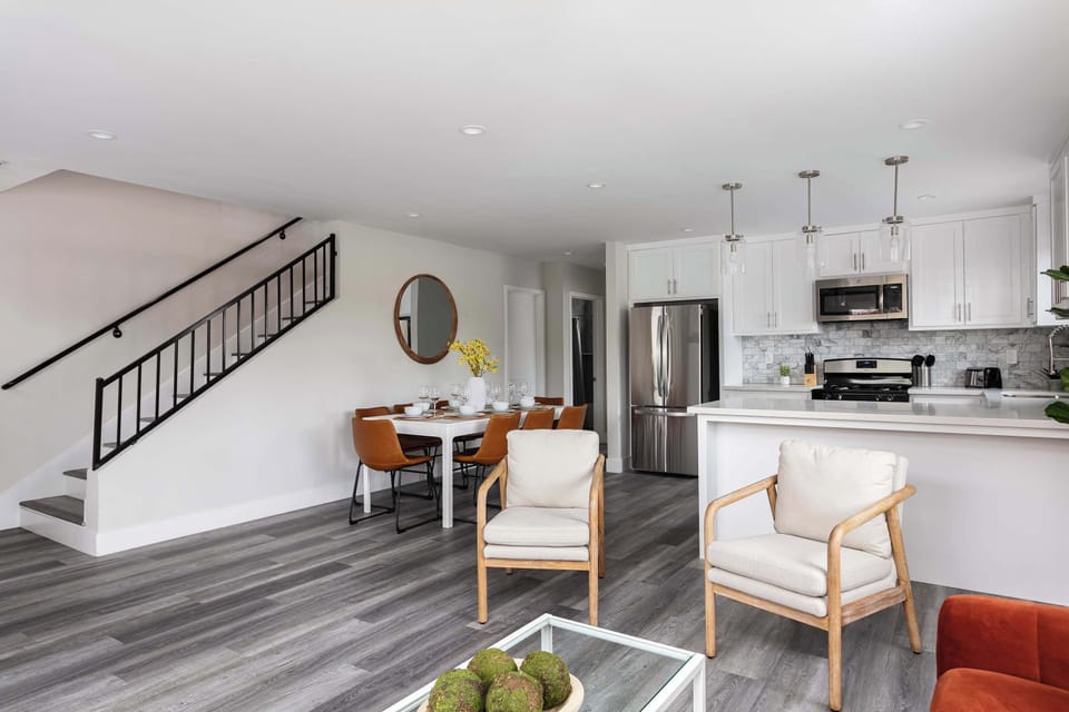 Spacious living room with modern seating and staircase view