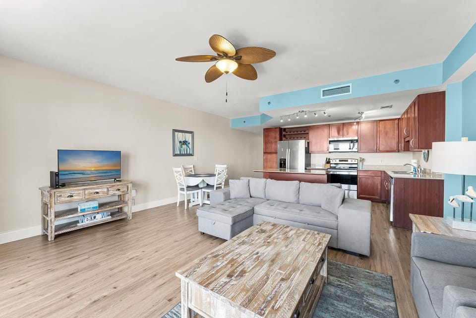 Open-concept living area with modern kitchen and coastal-inspired decor.