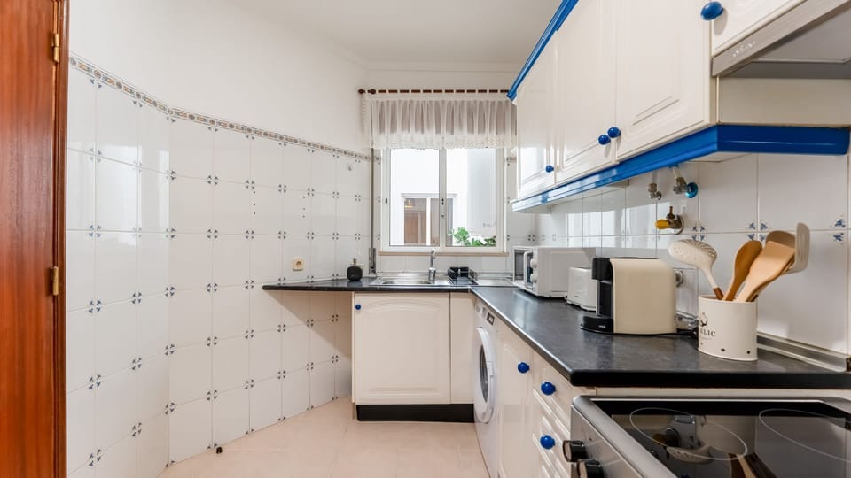 Charming kitchen with classic Portuguese tile, fully equipped with microwave, toaster, kettle, and washing machine.
#HomeAwayFromHome #SelfCatering #PortugalStay