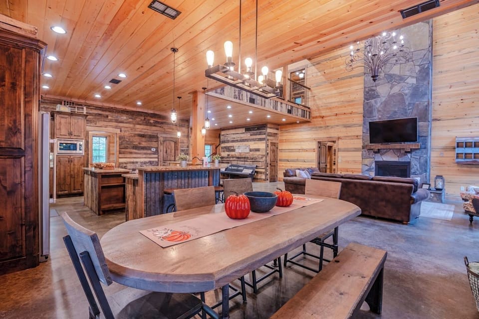 Enjoy a warm, rustic-modern interior featuring an open-concept kitchen, dining, and living area. Perfect for family gatherings, the space is beautifully designed with wood finishes, high ceilings, and a cozy ambiance.