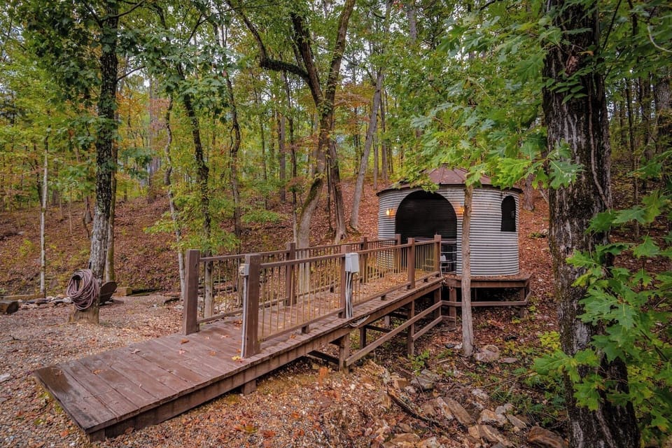 Cross a charming wooden bridge leading to a cozy, private retreat tucked away in the forest. This rustic yet modern cabin is surrounded by towering trees, creating a serene escape in Hochatown, near Broken Bow Lake.