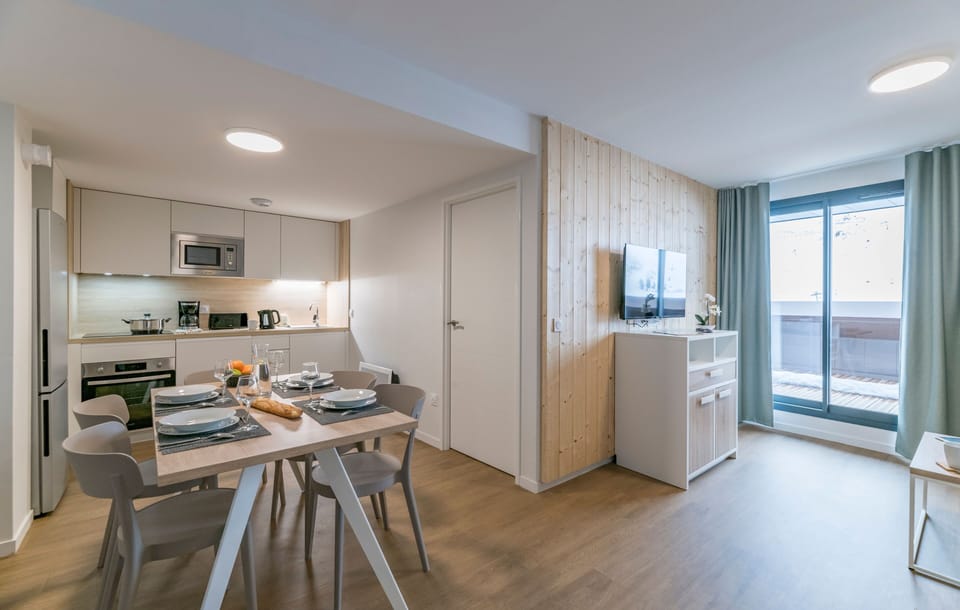 Gather around the inviting dining table in this open kitchen area, designed for effortless entertaining with sleek furnishings and seamless access to the living space.