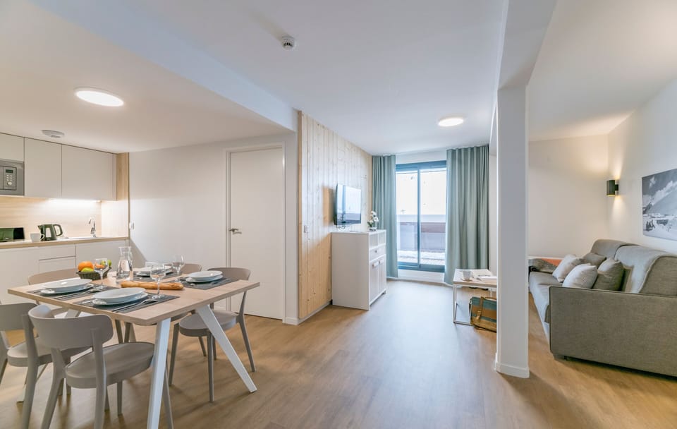 Experience modern comfort in this bright open-plan living space, featuring a sleek kitchen, cozy dining area, and a relaxing lounge, perfect for unwinding after a day of adventures.