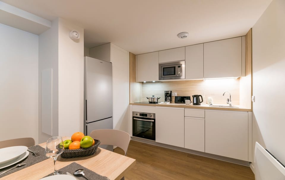 Cook your favorite meals in this modern kitchen, equipped with sleek appliances and a welcoming dining space, ideal for family gatherings or intimate dinners.