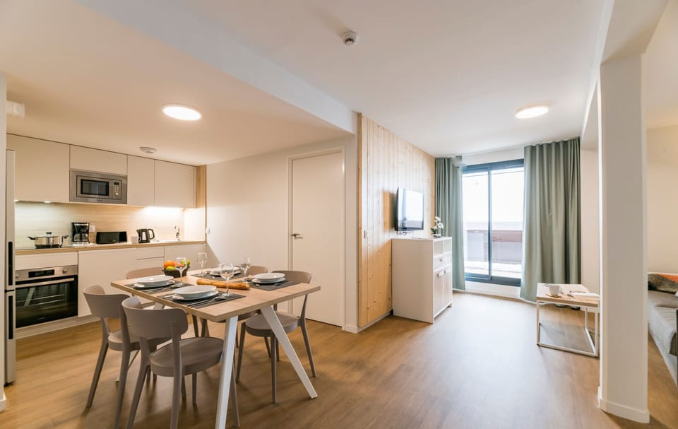 Gather around the beautifully set dining table in this well-appointed apartment, a perfect blend of modern décor and rustic charm, making every meal feel special.