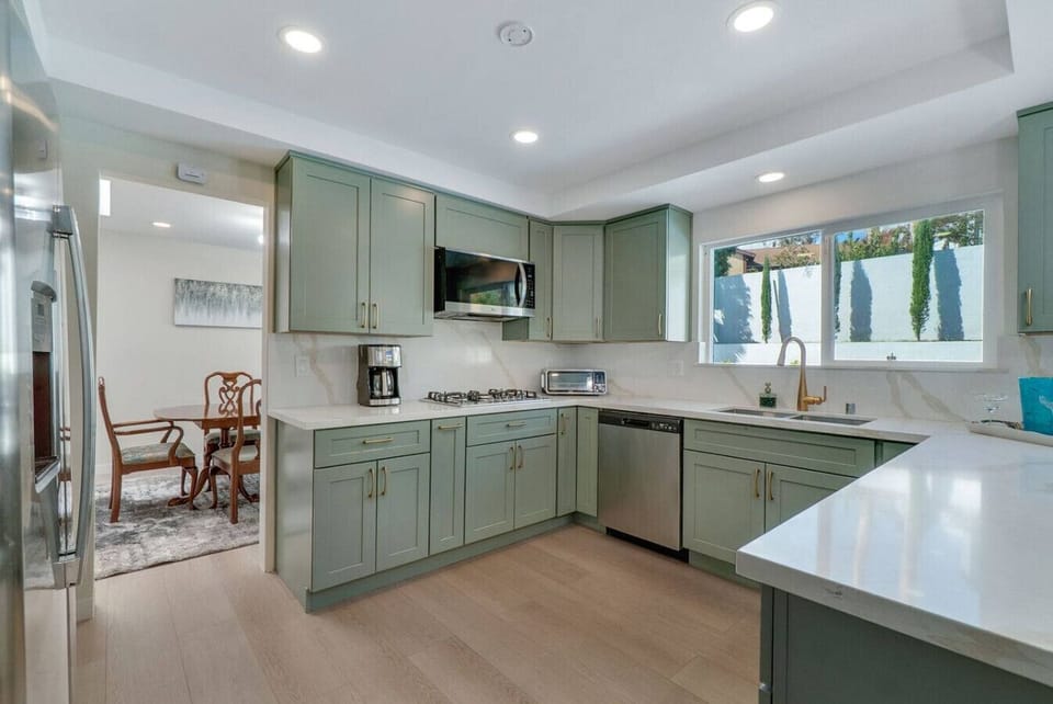 Fully stocked kitchen with stainless steel appliances and 12-cup drip coffee maker.