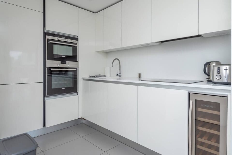 Sleek kitchen with double oven, wine fridge, and all the basics covered
