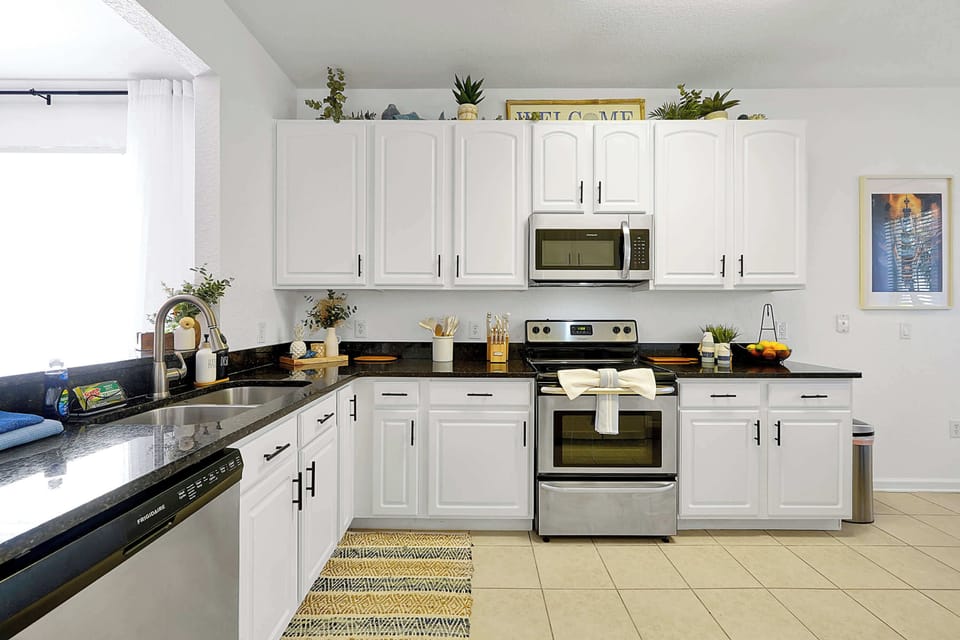 Modern kitchen with stainless steel appliances and black granite countertops