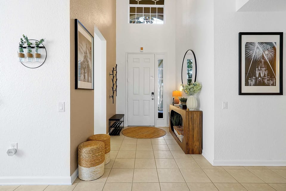 Entryway with natural light, decorative wall art, and functional storage seating.