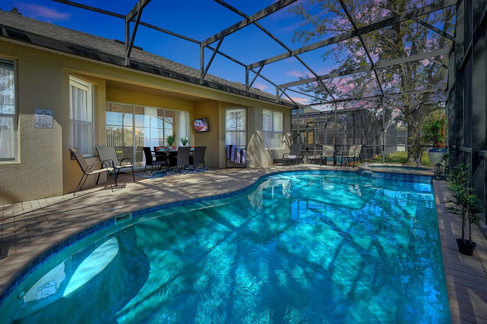 Enjoy a relaxing swim in the screened-in pool area with outdoor dining and lounge seating.