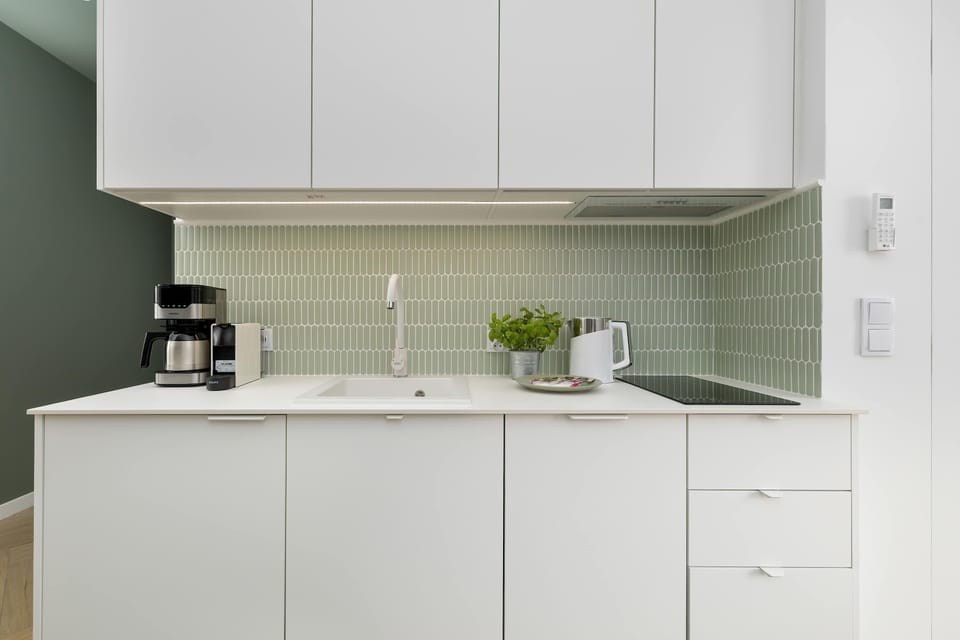 The sleek design of the kitchenette blending seamlessly with the living area.