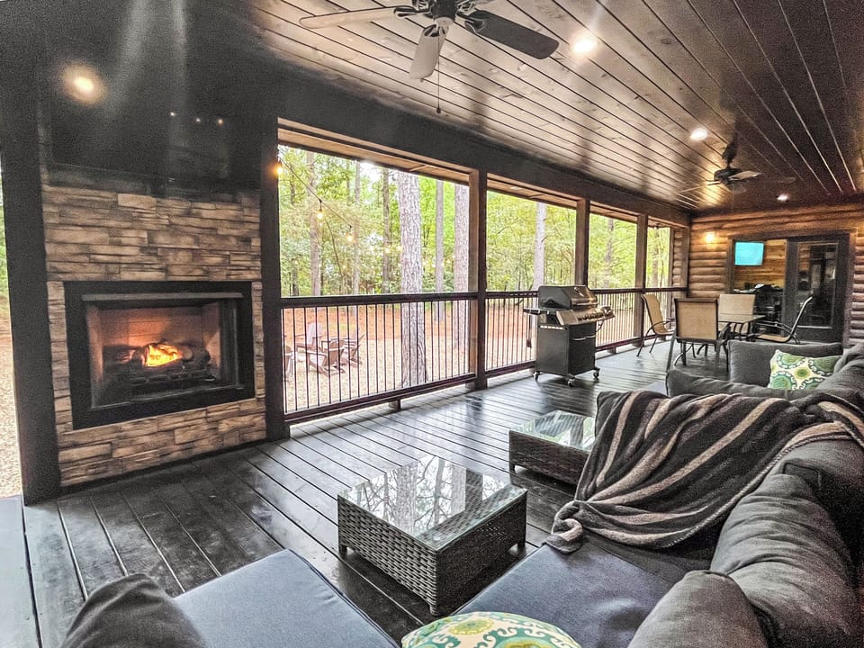 Enjoy outdoor living at its finest with a screened-in porch, stone fireplace, and grill for unforgettable evenings.