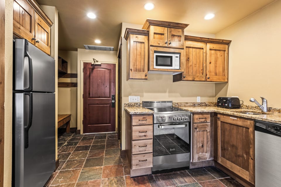 The efficient kitchen with oven, refrigerator, microwave, and dishwasher.