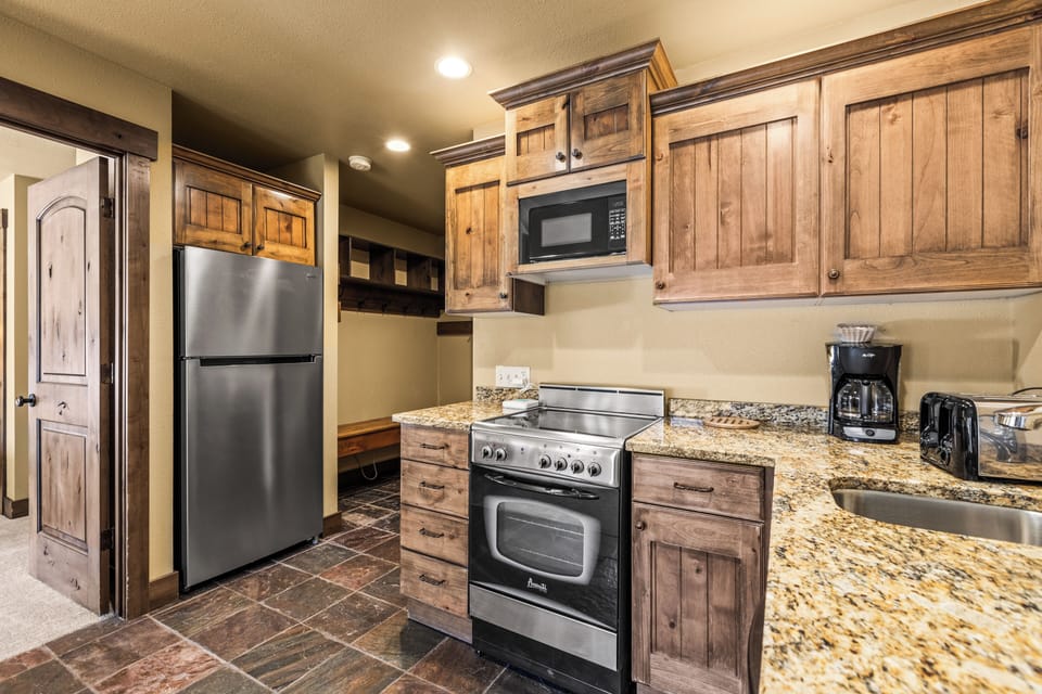 Step into your own rustic mountain retreat kitchen, where warm wood cabinets and granite countertops create the perfect space for cooking.