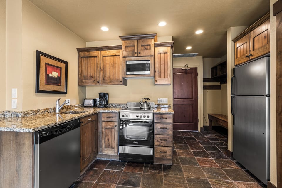 The efficient kitchen with oven, refrigerator, microwave, and dishwasher.