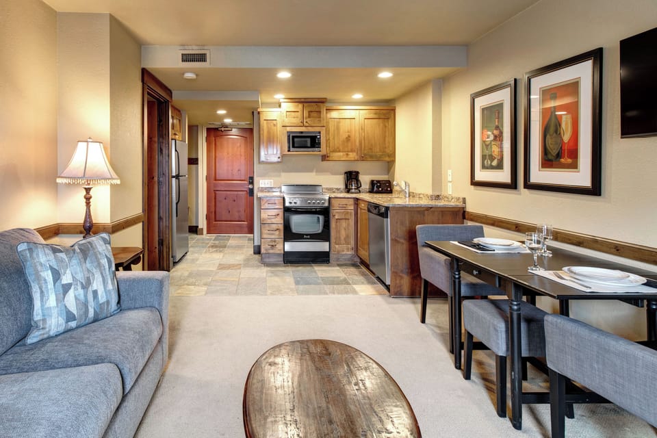 Your cozy open-concept space combines a fully equipped kitchen with warm wood cabinets and a stylish dining area.