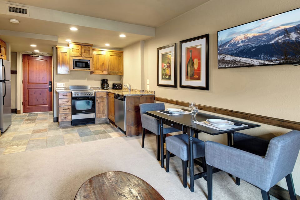 Your cozy open-concept space combines a fully equipped kitchen with warm wood cabinets and a stylish dining area.