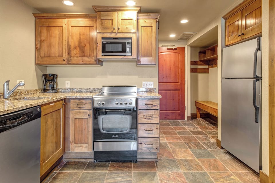 Your fully equipped kitchen with warm wood cabinets and granite counters.