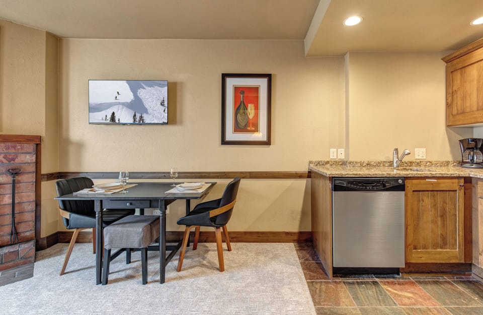 Your cozy open-concept space combines a fully equipped kitchen with warm wood cabinets and a stylish dining area.