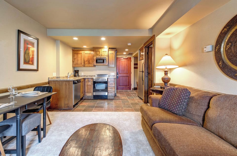 Your cozy open-concept space combines a fully equipped kitchen with warm wood cabinets and a stylish dining area.