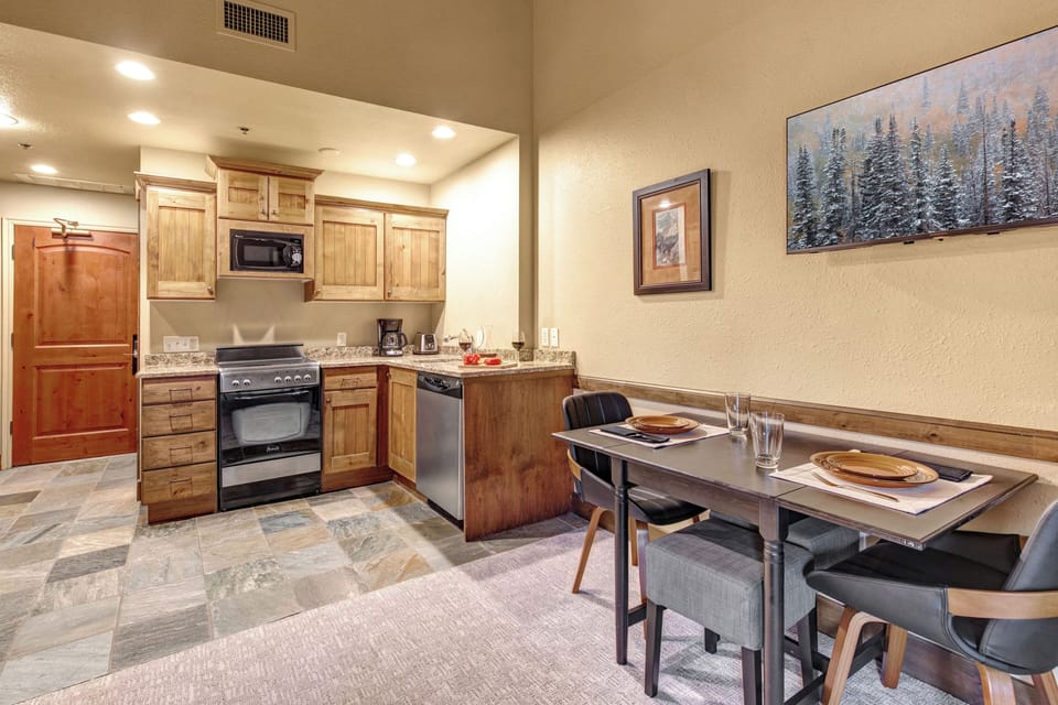 Your fully equipped kitchen awaits with warm wood cabinets, granite countertops, and modern stainless steel appliances.