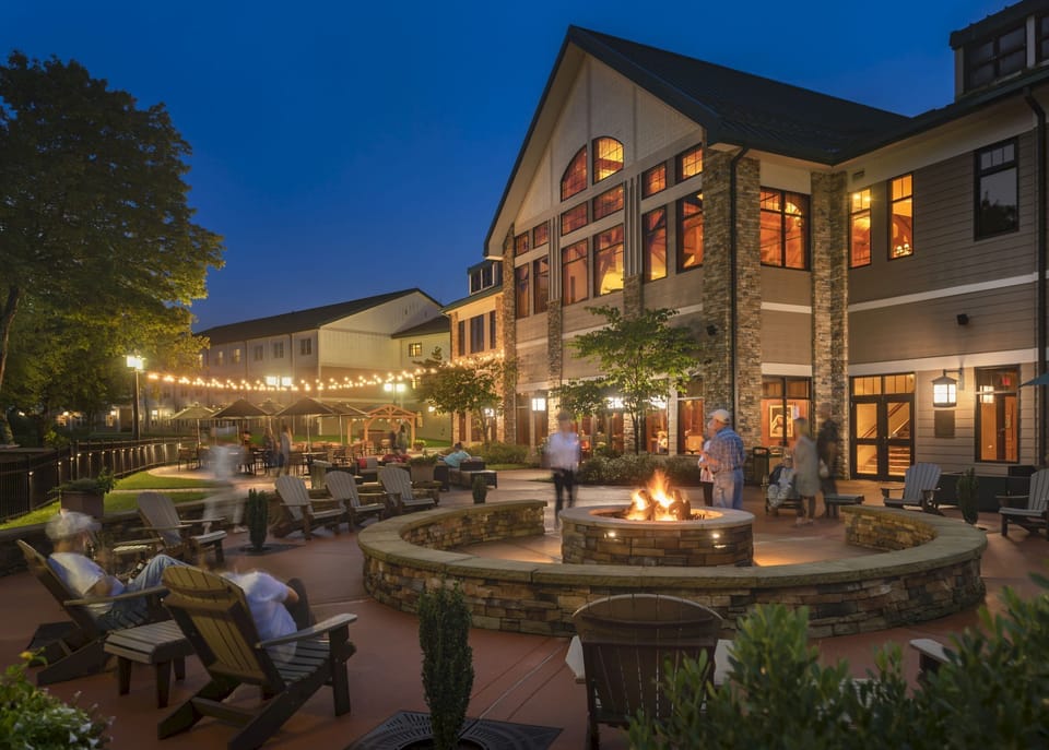 Golden hour settles over the Adirondack-style lodge, setting the tone for cozy evenings in front of a fire pit and patio.