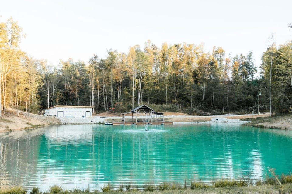 Crystal-clear private pond with a covered dock and fountain, surrounded by peaceful forest views. 🌲💧