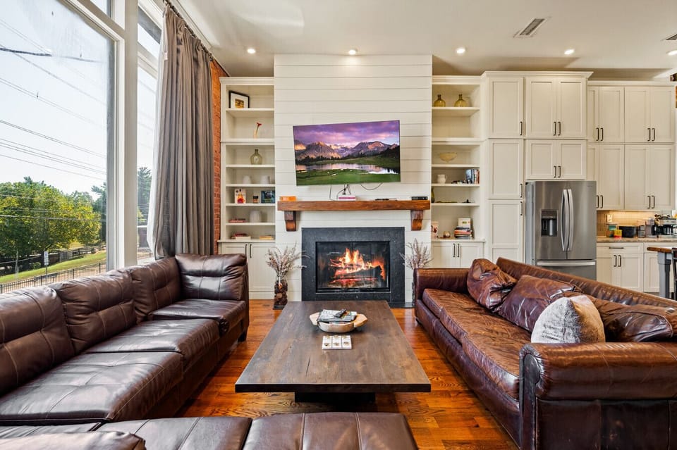 Living Room| Bright open-concept space with leather seating, cozy fireplace, and smart TV