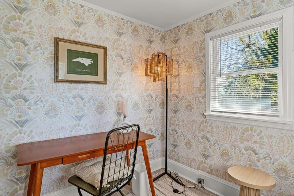 Cozy workspace nook w/ warm wallpaper, natural light, & a quiet spot to focus or journal.