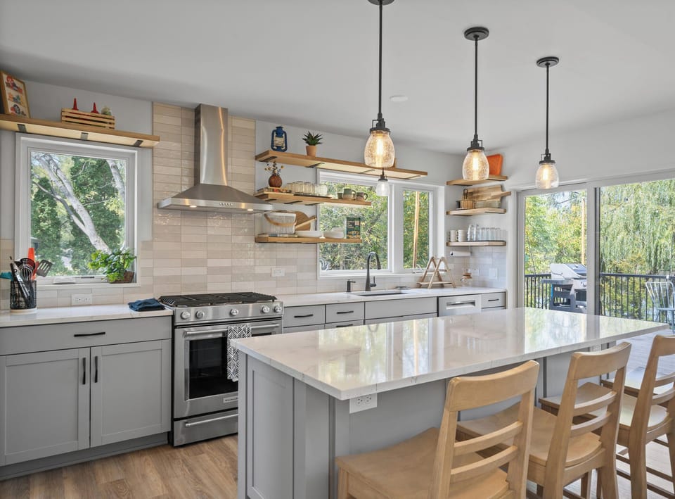 Kitchen with breakfast bar seating, sliding door to balcony.