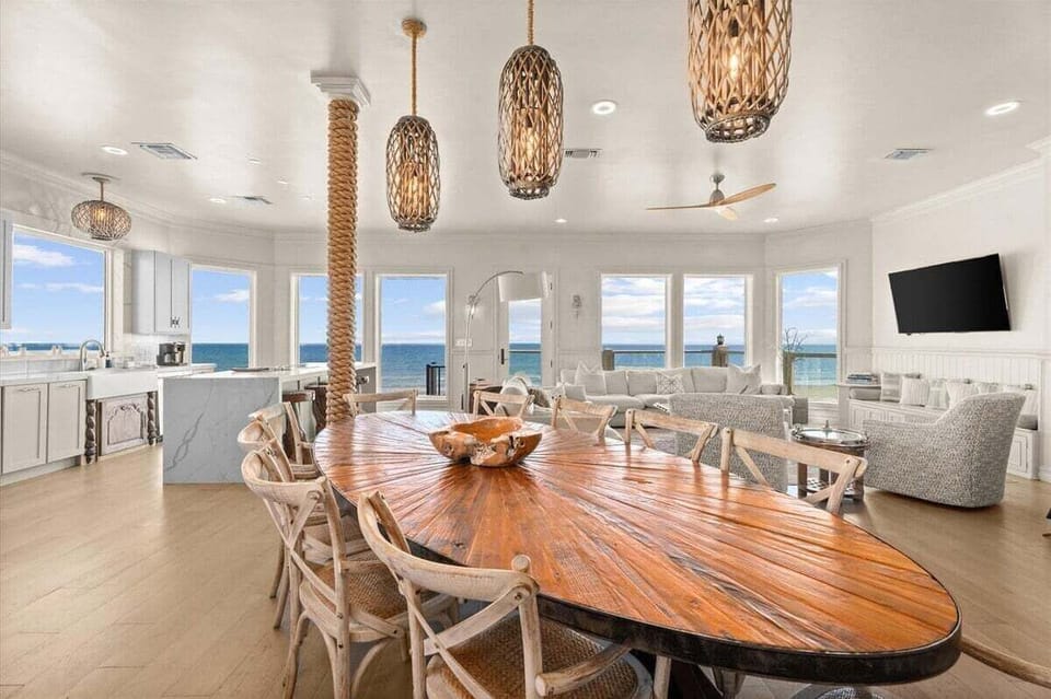 A sweeping open-concept dining area commands the heart of the home, framed by ocean views that make every meal feel like a celebration.