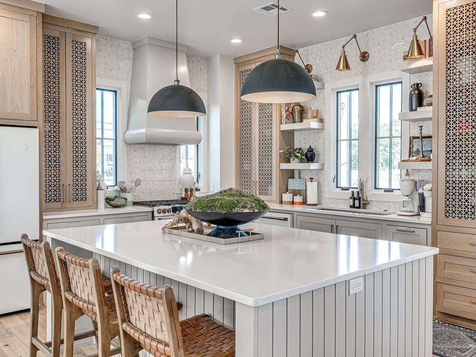 2. Bright kitchen island with woven barstools, Café appliances, and pendant lighting — perfect for gathering, dining, or morning coffee.