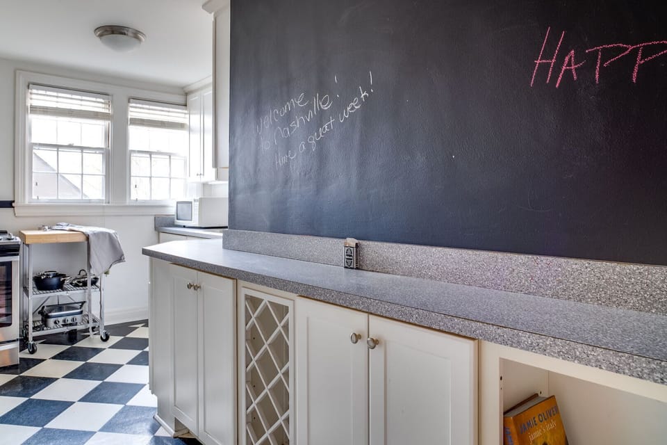 Full kitchen featuring crisp white cabinetry and sleek granite countertops