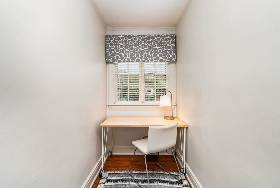 Bright open floor living space featuring cozy furnishings, a smart TV, and a work station.