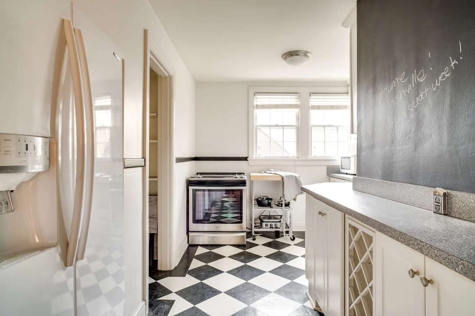Full kitchen featuring crisp white cabinetry and sleek granite countertops