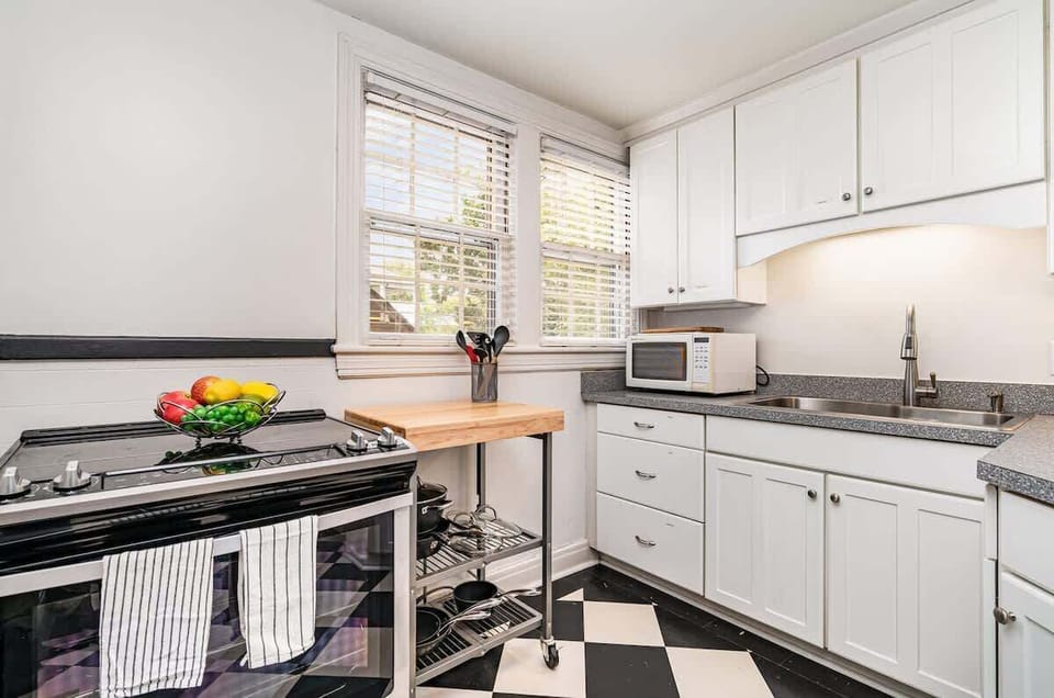Full kitchen featuring crisp white cabinetry and sleek granite countertops