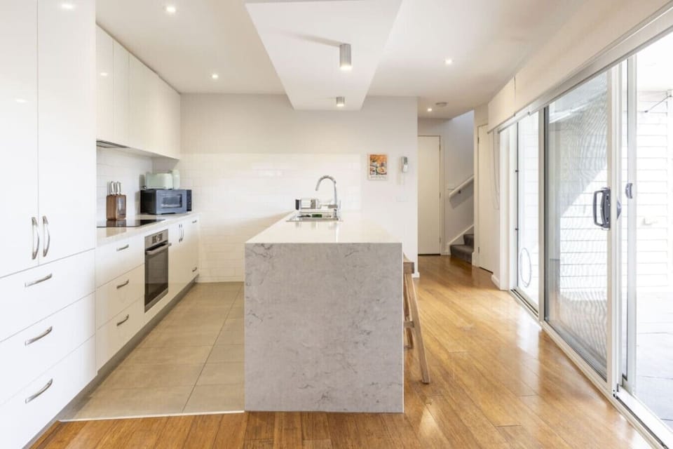 Modern kitchen with island bench, full appliances and everything needed for cooking at home.