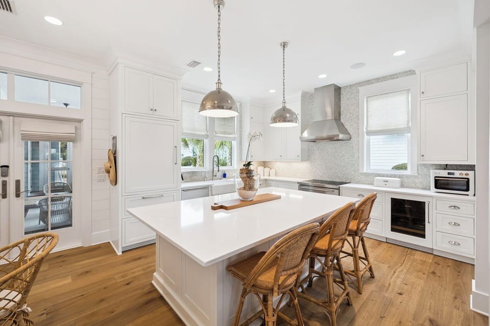 Cook gourmet meals in this stunning white kitchen with marble countertops, pendant lighting, and a spacious island perfect for gathering.