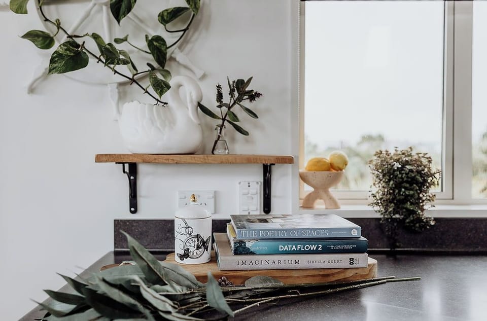 Little moments, beautifully placed - where books rest and blooms lean into light.